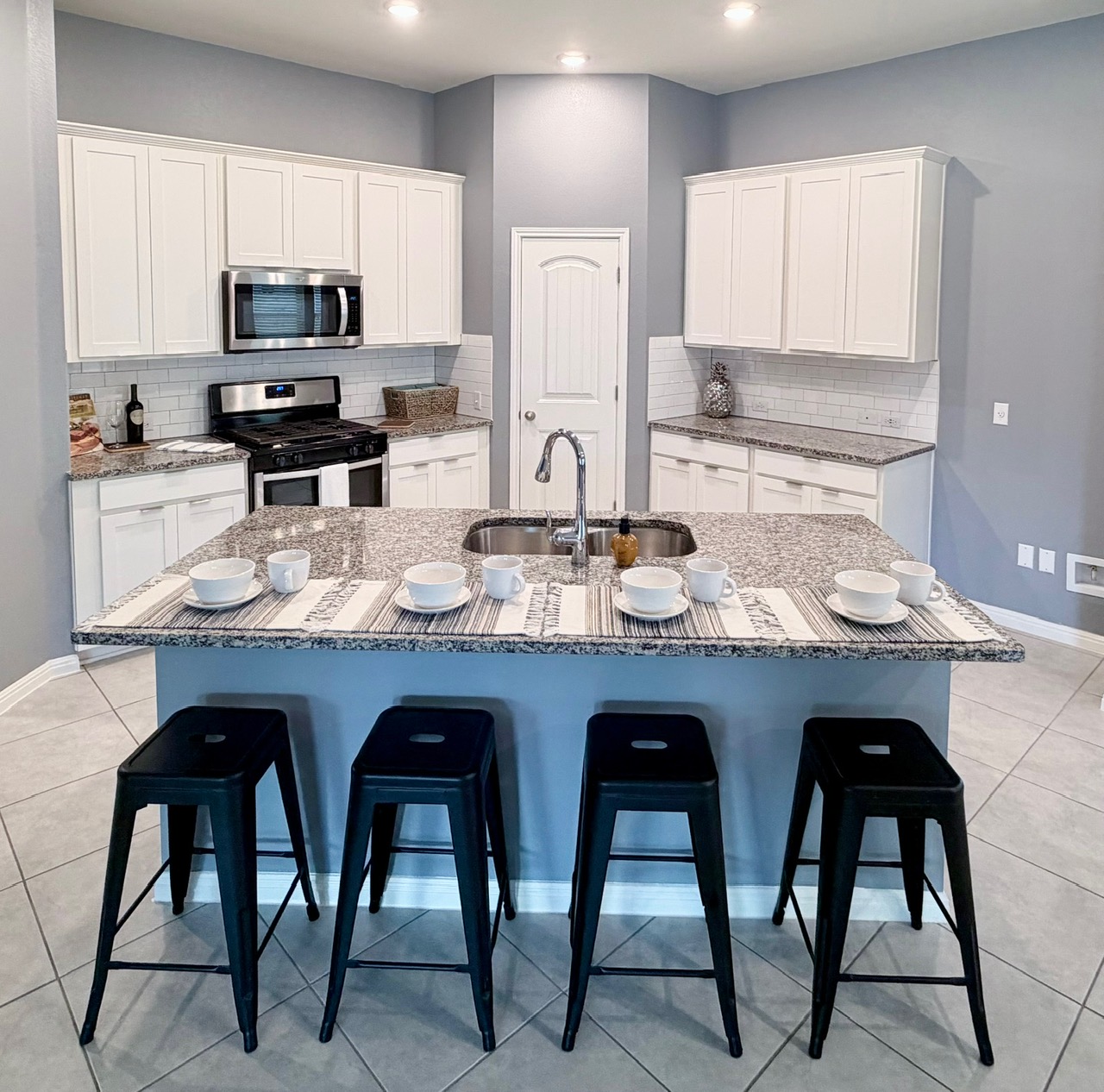1005 Sundrops Street Leander, TX 78641 - Photo 5 of 39 a kitchen with stainless steel appliances granite countertop white cabinets a sink and dishwasher