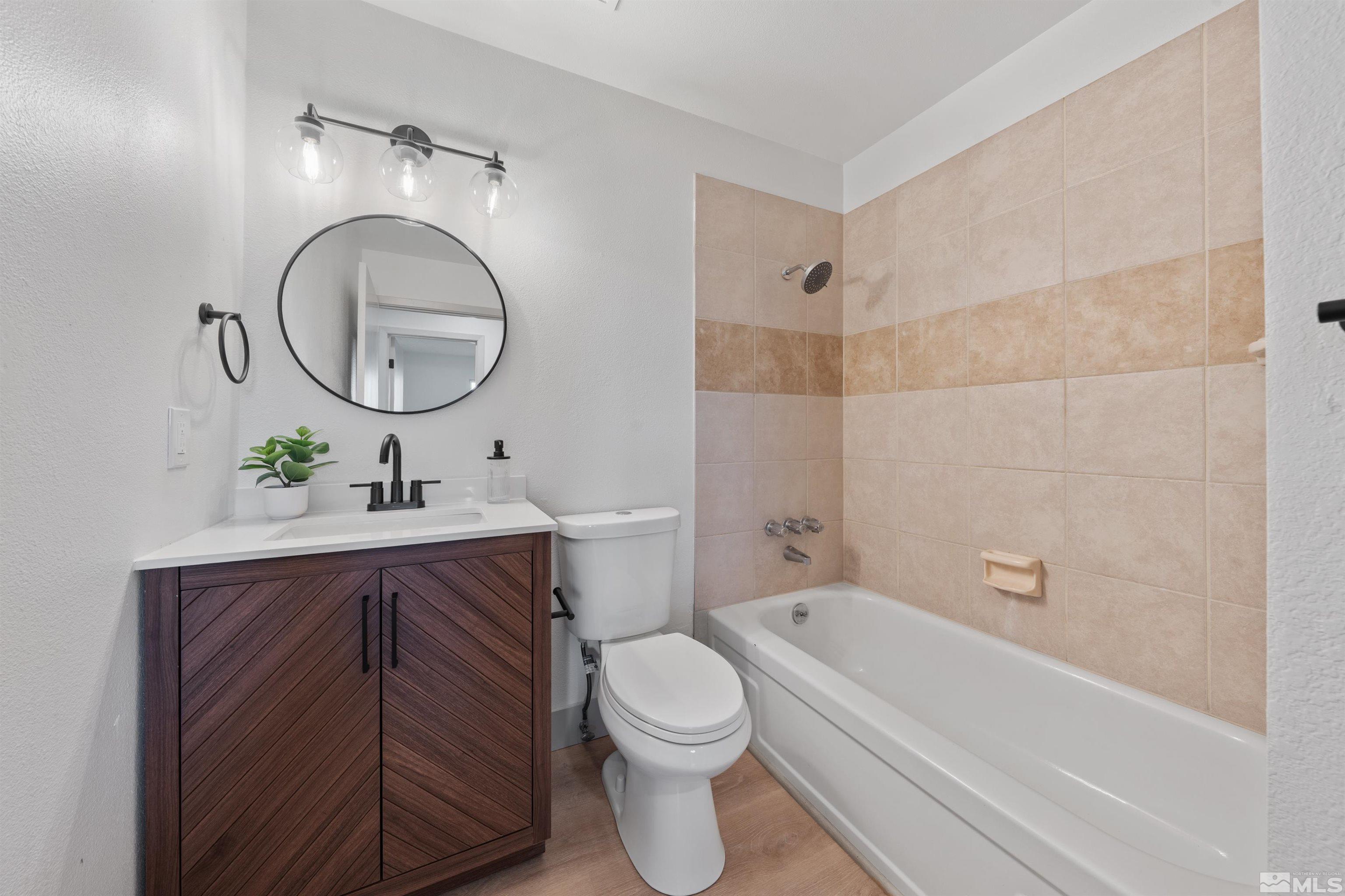 7750 Yorkshire Drive Reno, NV 89506 - Photo 20 of 33 a bathroom with a toilet a sink a mirror and bathtub