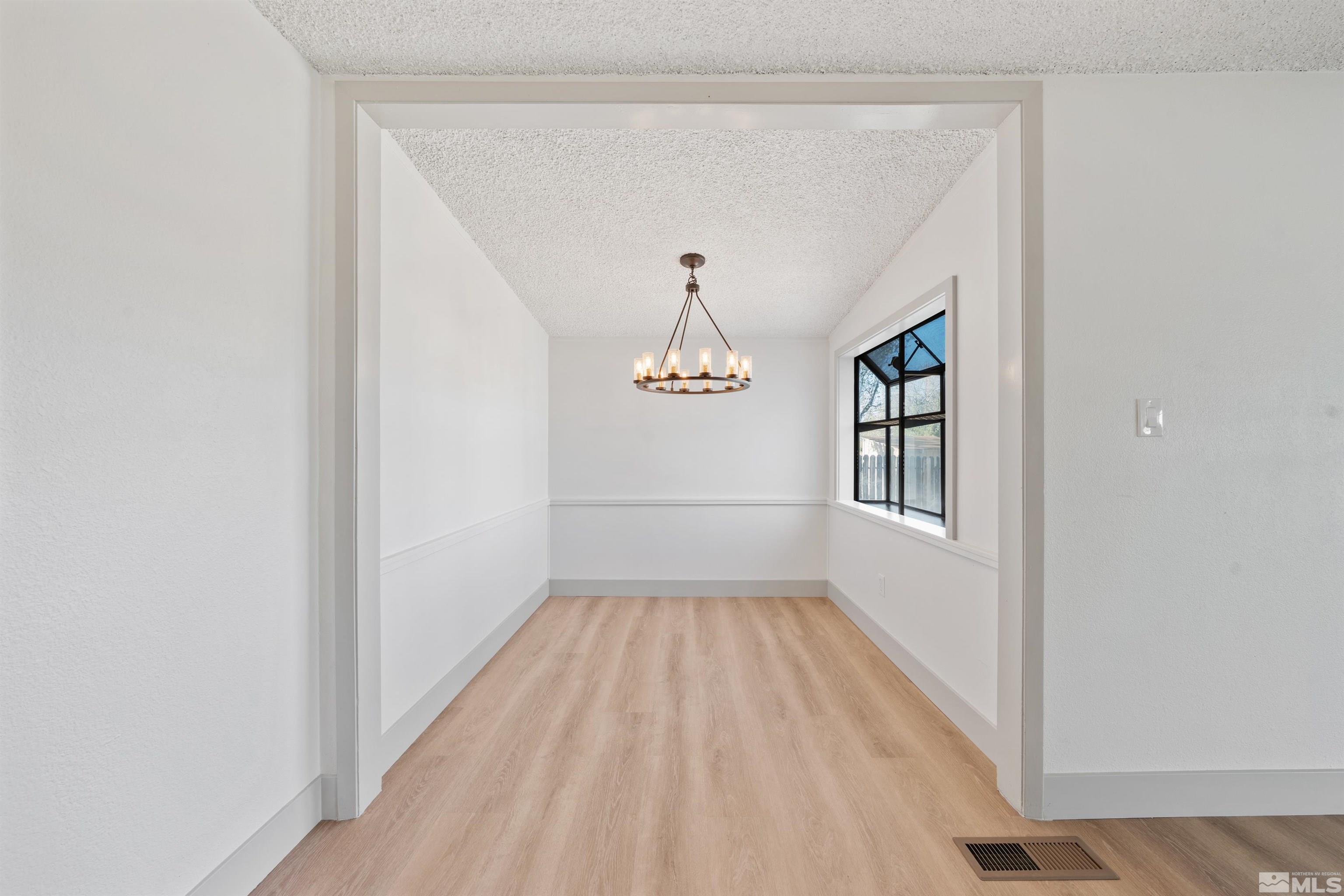 7750 Yorkshire Drive Reno, NV 89506 - Photo 5 of 33 a view of a room with wooden floor windows and ceiling fan
