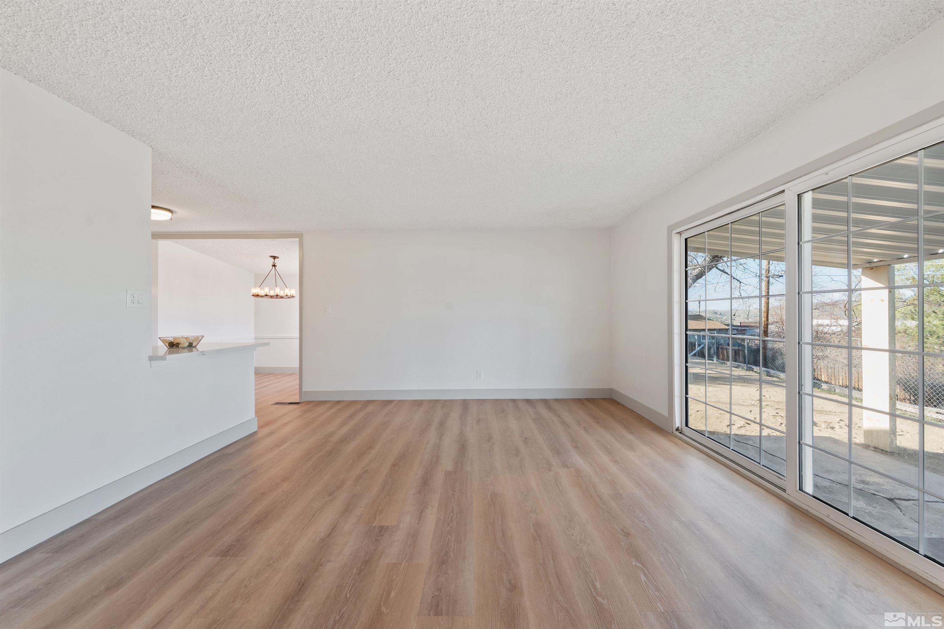 7750 Yorkshire Drive Reno, NV 89506 - Photo 8 of 33 an empty room with wooden floor and windows