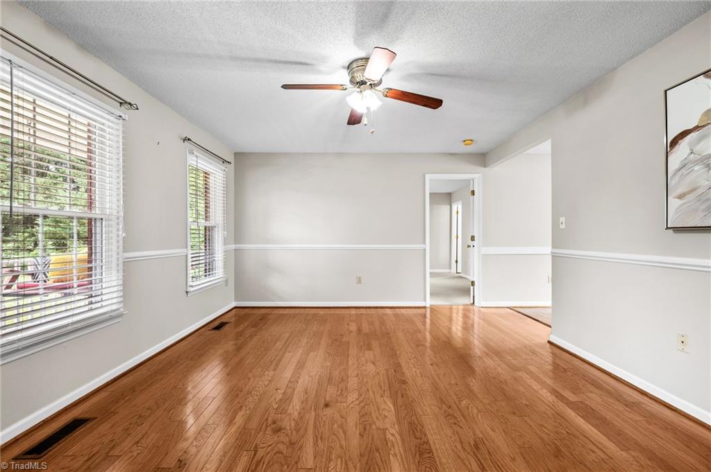 3603 Fieldview Road Pleasant Garden, NC 27313 - Photo 3 of 31 Living room with double windows, wood flooring, chair rail & ceiling fan.