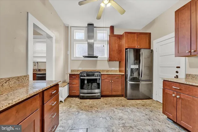 a kitchen with stainless steel appliances granite countertop a refrigerator a stove and a sink