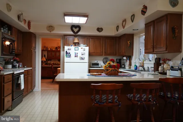 a kitchen with kitchen island granite countertop a sink cabinets and stainless steel appliances