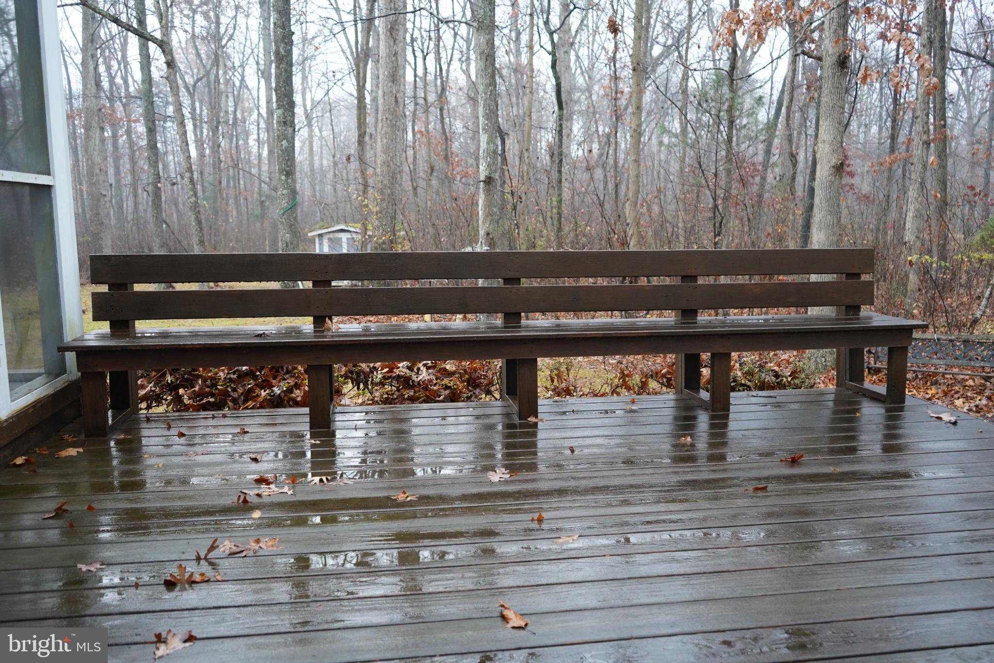 7323 O'Keefe Road Bealeton, VA 22712 - Photo 5 of 26 Rain-kissed bench in a tranquil forest setting.