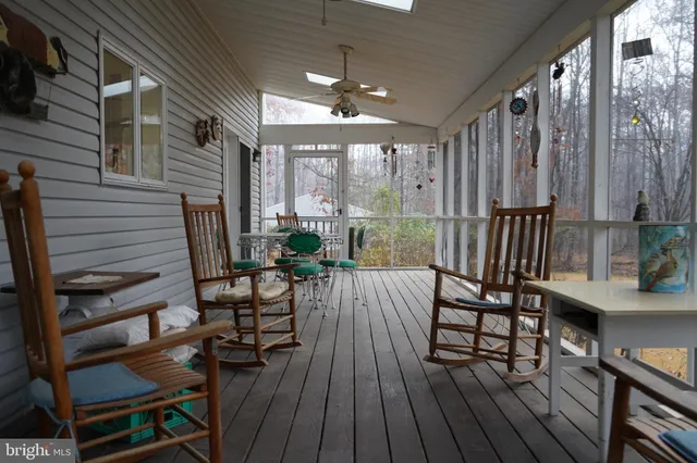 a view of a patio with dining table and chairs with wooden floor and fence