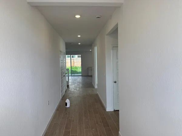 a view of a hallway with wooden floor