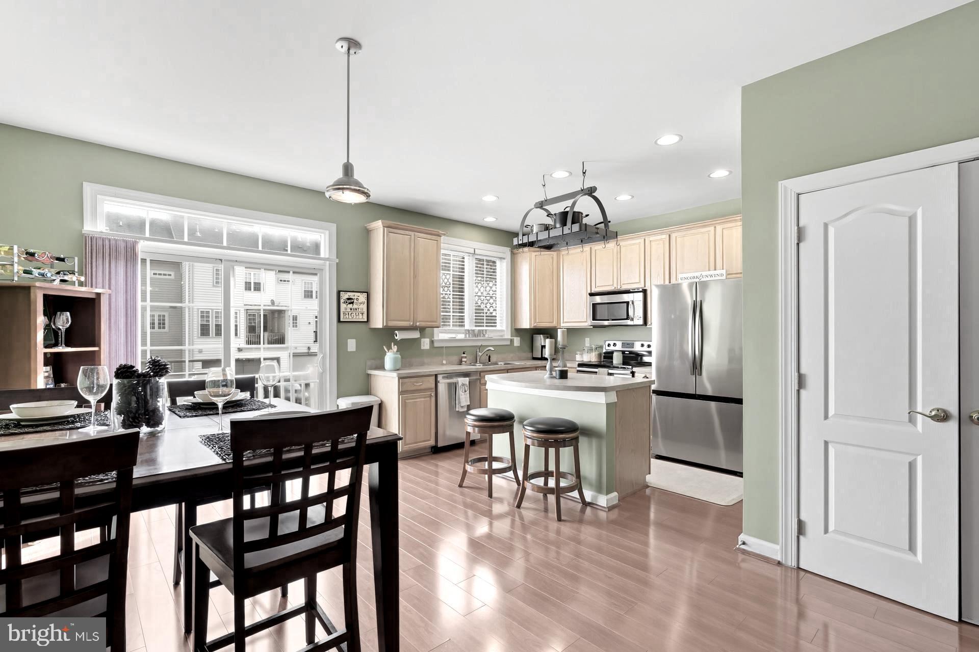 10423 Rifle Road Bristow, VA 20136 - Photo 4 of 39 a dining room with stainless steel appliances granite countertop a dining table chairs and couches