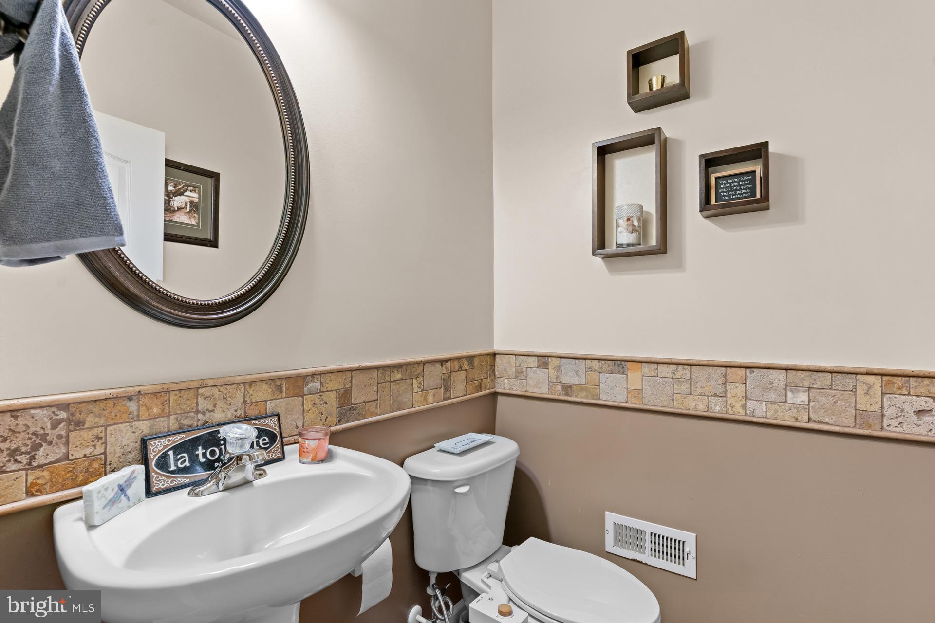 10423 Rifle Road Bristow, VA 20136 - Photo 6 of 39 a bathroom with a toilet a sink and mirror
