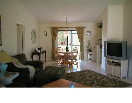 938 Southwest Bay State Road Port St. Lucie, FL 34953 - Photo 2 of 16 a living room with furniture flat screen tv and a large window