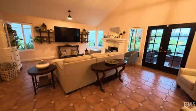 a kitchen with stainless steel appliances a sink a stove a refrigerator cabinets and chairs