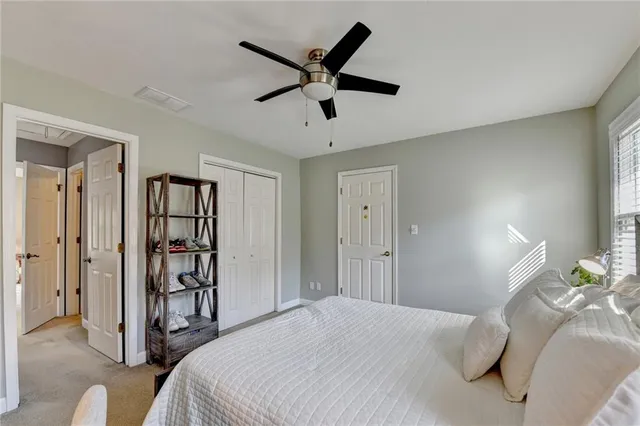 a bedroom with a bed and a ceiling fan