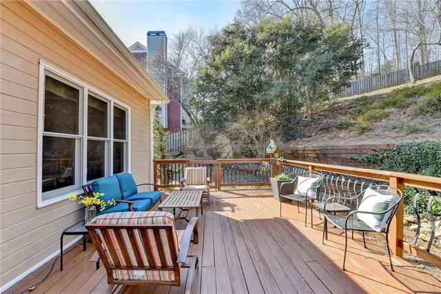 a balcony with wooden floor and outdoor seating