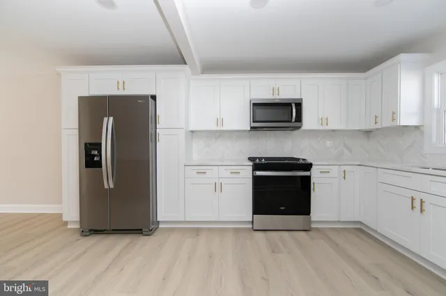 a kitchen with granite countertop a refrigerator stove and sink