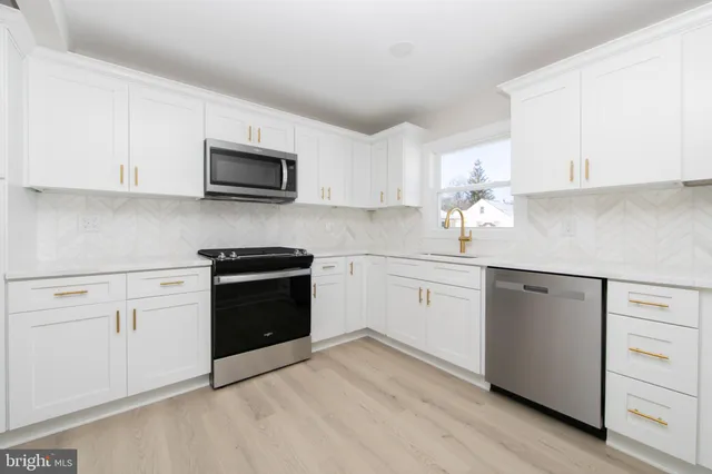 a kitchen with white cabinets and stainless steel appliances