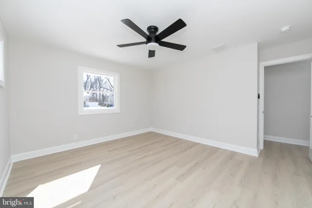 an a view of room with a ceiling fan and wooden floor
