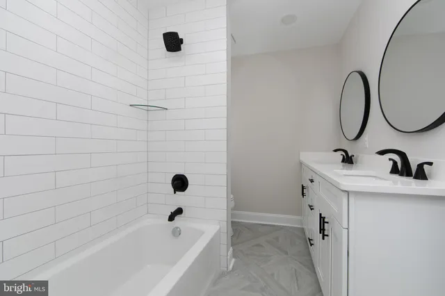 a bathroom with a tub sink and mirror