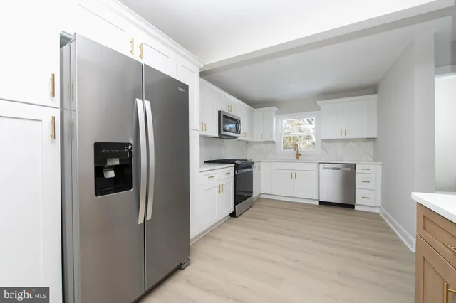 a kitchen with stainless steel appliances a refrigerator and a stove top oven