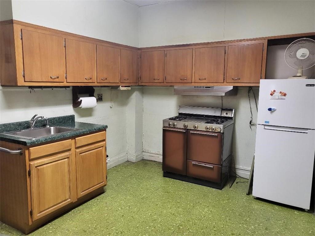 77 Webster Avenue Brooklyn, NY 11218 - Photo 2 of 6 a kitchen with granite countertop a white stove top oven and cabinets