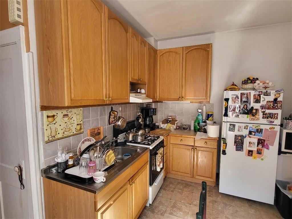 77 Webster Avenue Brooklyn, NY 11218 - Photo 4 of 6 a kitchen with a refrigerator and a stove