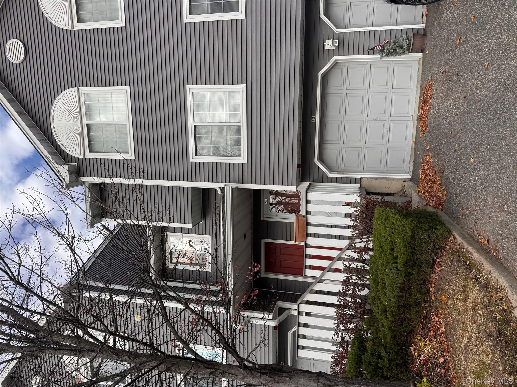 Traditional home with covered porch and asphalt driveway