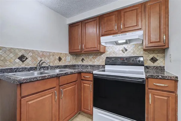 a kitchen with stainless steel appliances granite countertop a sink stove and cabinets