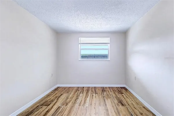 a view of a room with wooden floor and window