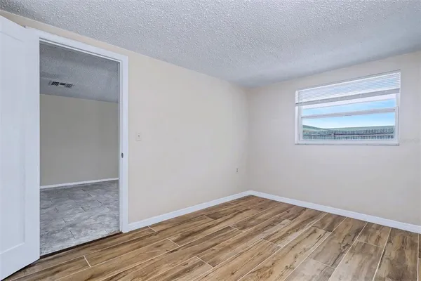 a view of empty room with wooden floor