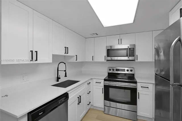 a kitchen with stainless steel appliances a sink stove and refrigerator