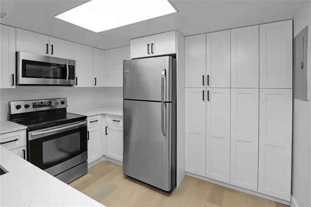 a white refrigerator freezer and a stove sitting inside of a kitchen