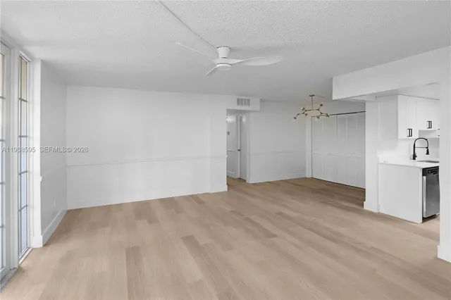 a view of empty room with wooden floor and window