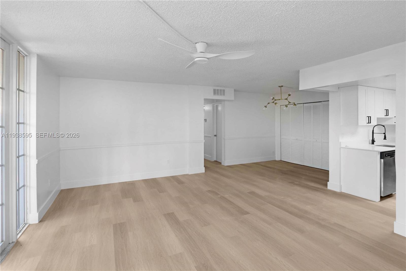 8309 Southwest 142nd Avenue, Unit G112 Miami, FL 33183 - Photo 5 of 28 a view of empty room with wooden floor and window