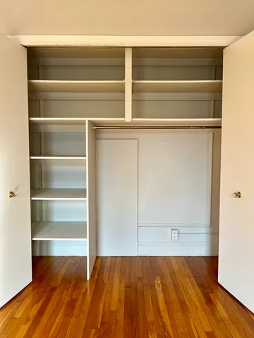 a view of a room with wooden floor and cabinet