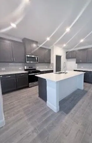 a large kitchen with stainless steel appliances and a sink