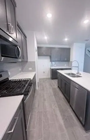 a kitchen with a stove sink and cabinets