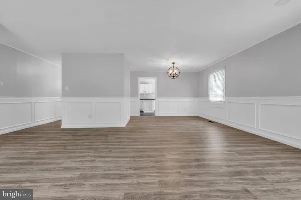 a view of empty room with wooden floor and windows