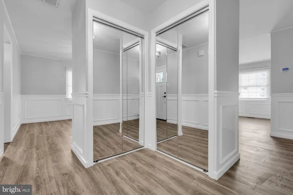 an empty room with wooden floor door and windows