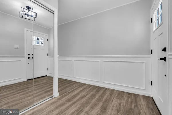 an empty room with wooden floor and mirror