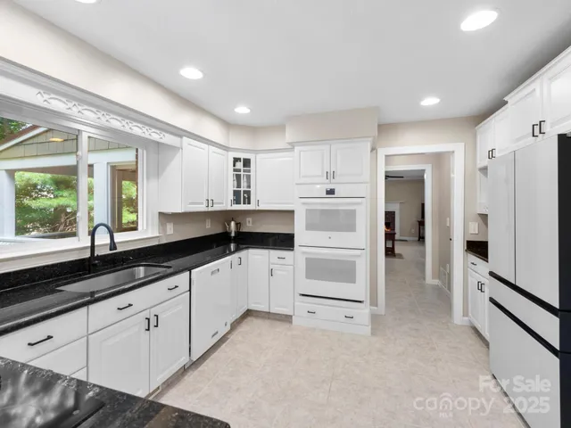 a kitchen with white cabinets and white appliances