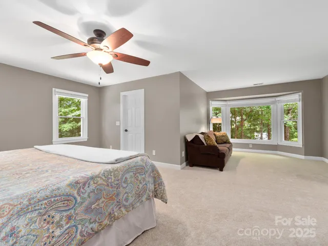 a bedroom with a bed and a large window