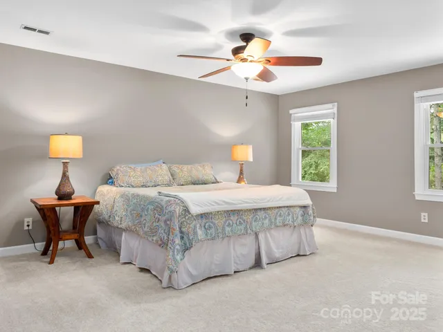 a spacious bedroom with a bed and a chandelier