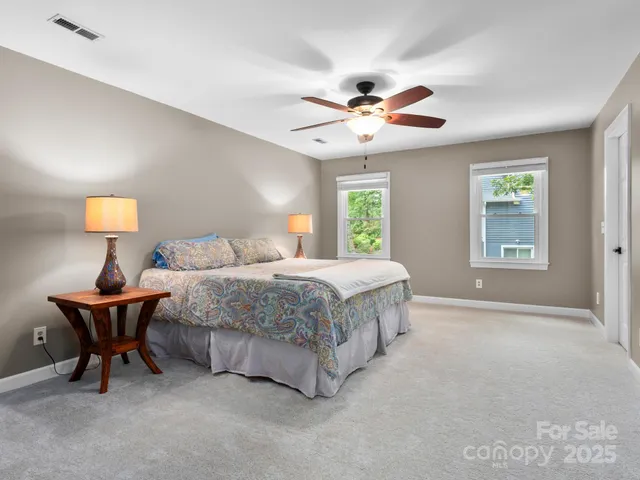 a spacious bedroom with a bed and a chandelier