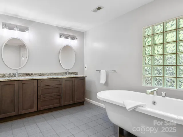 a spacious bathroom with a granite countertop sink and a mirror