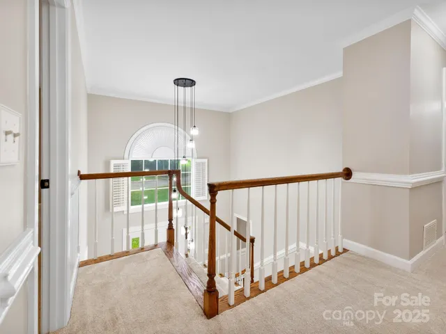 a view of staircase with railing and a chandelier