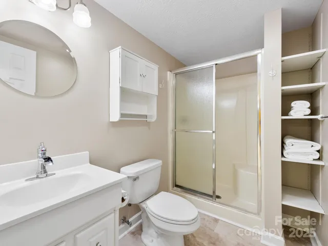 a bathroom with a sink a toilet and shower