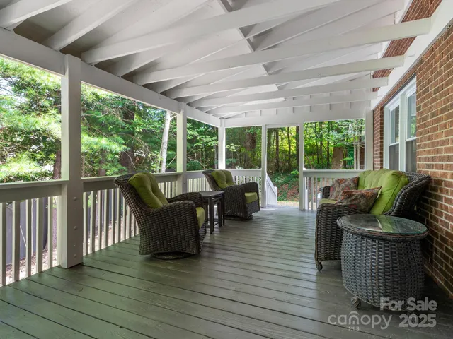 a living room with patio furniture and floor to ceiling windows