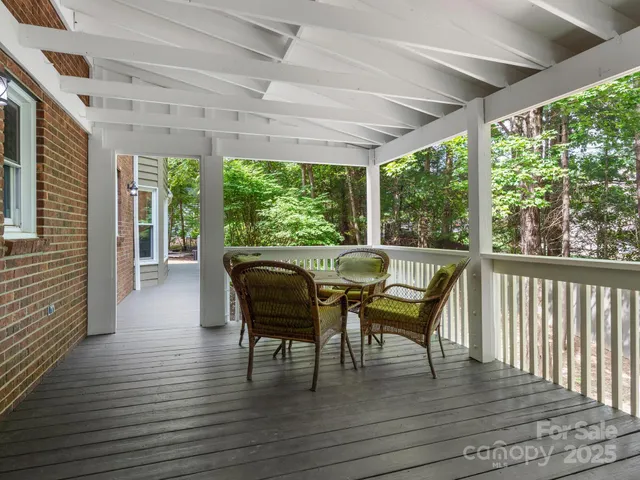 a view of a porch with furniture and wooden floor