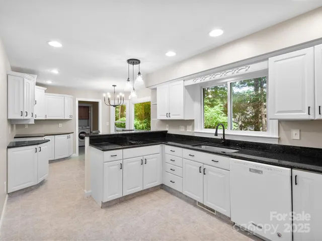 a kitchen with granite countertop a sink cabinets and window