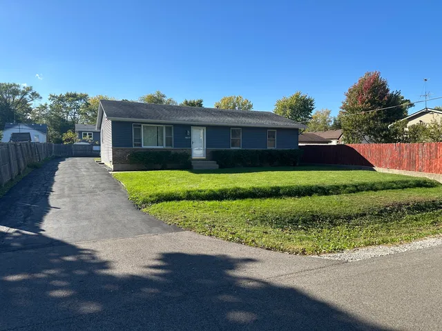 a view of a house with a yard and potted plants