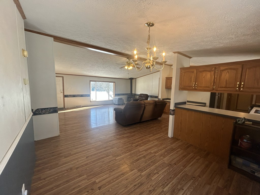 321 Ridge Avenue Avenue Strattanville, PA 16258 - Photo 6 of 29 a kitchen with stainless steel appliances kitchen island granite countertop wooden floors and a view of living room