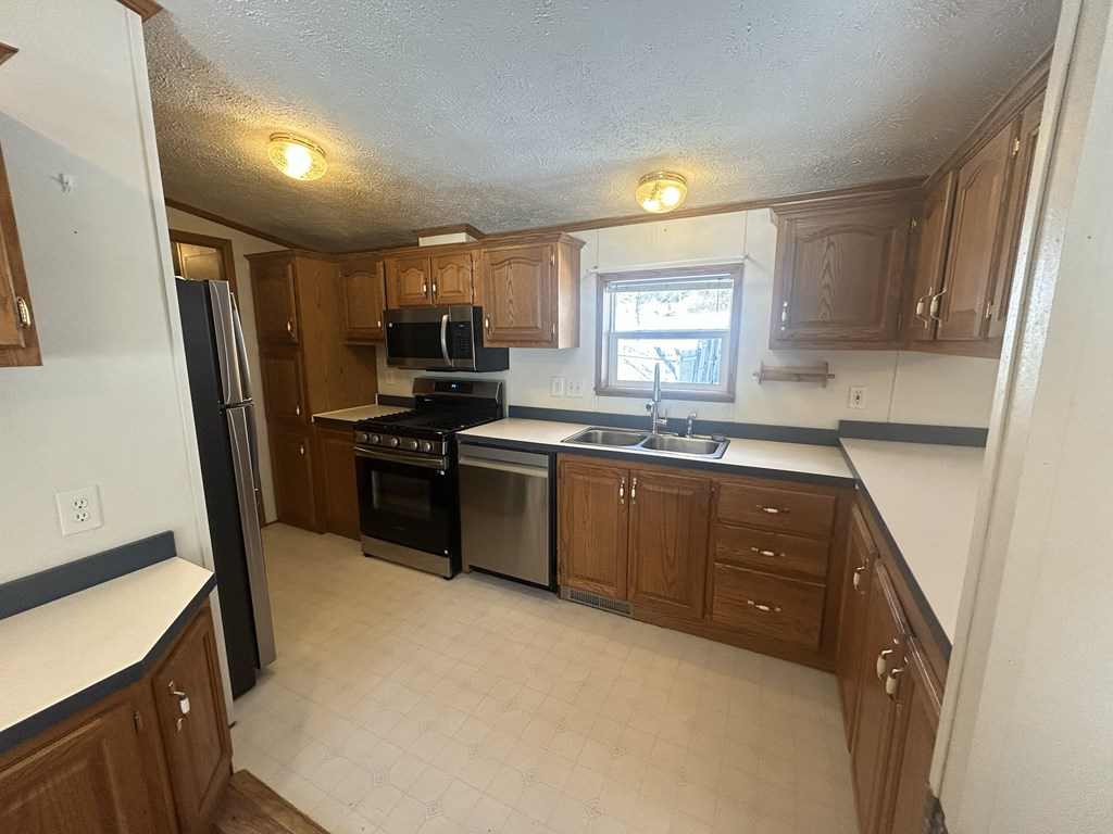 321 Ridge Avenue Avenue Strattanville, PA 16258 - Photo 8 of 29 a kitchen with a sink a window and stainless steel appliances